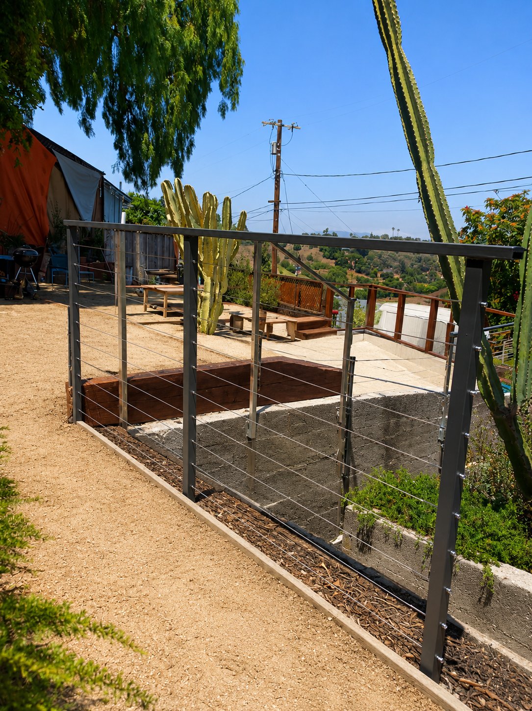 Cable railing along hillside garden path in Los Angeles — black steel posts with stainless cable infill