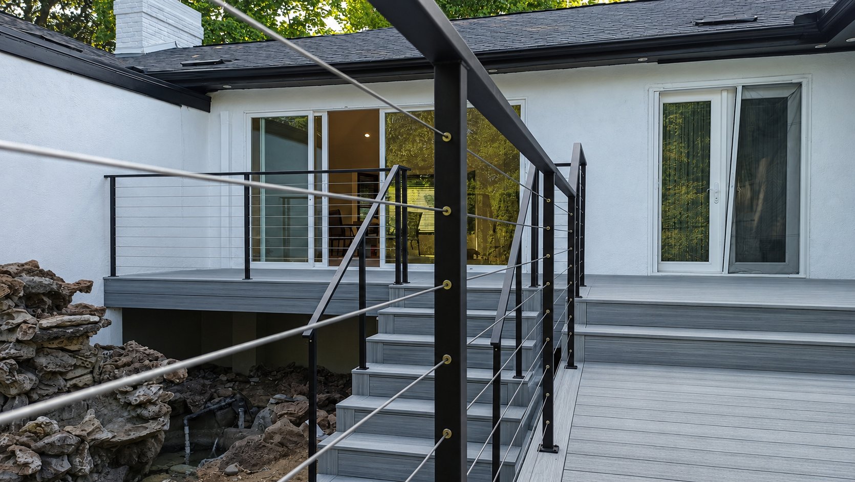 Stainless cable railing on steps connecting two composite deck levels in Los Angeles
