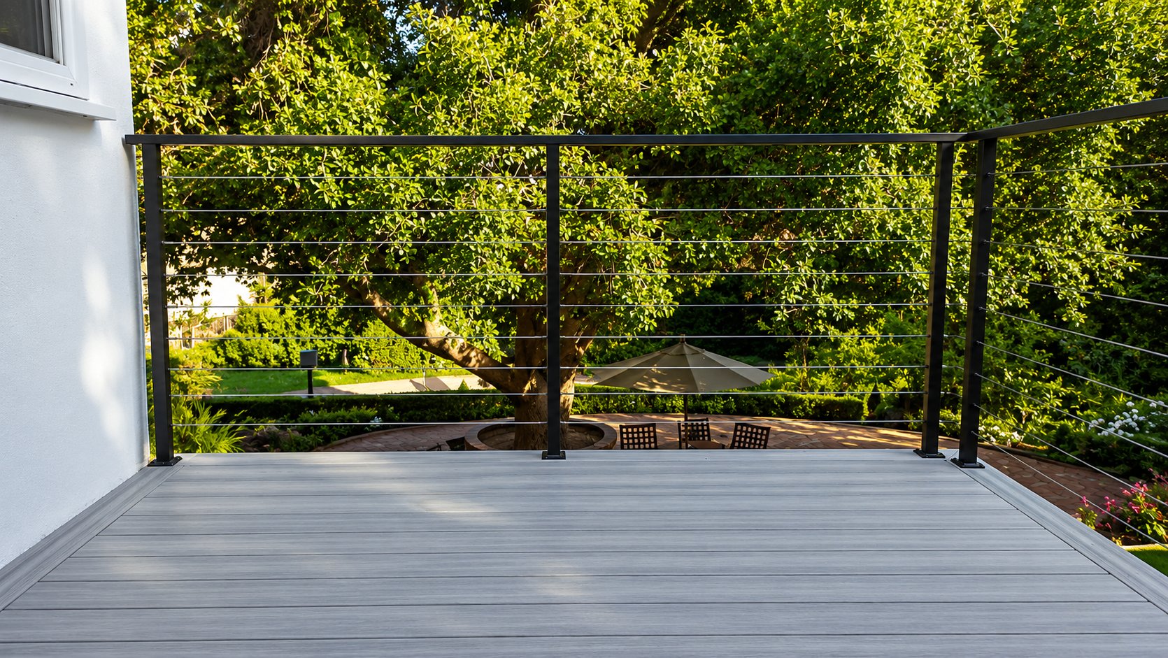 Black-frame cable railing on a gray composite deck with garden views in Los Angeles