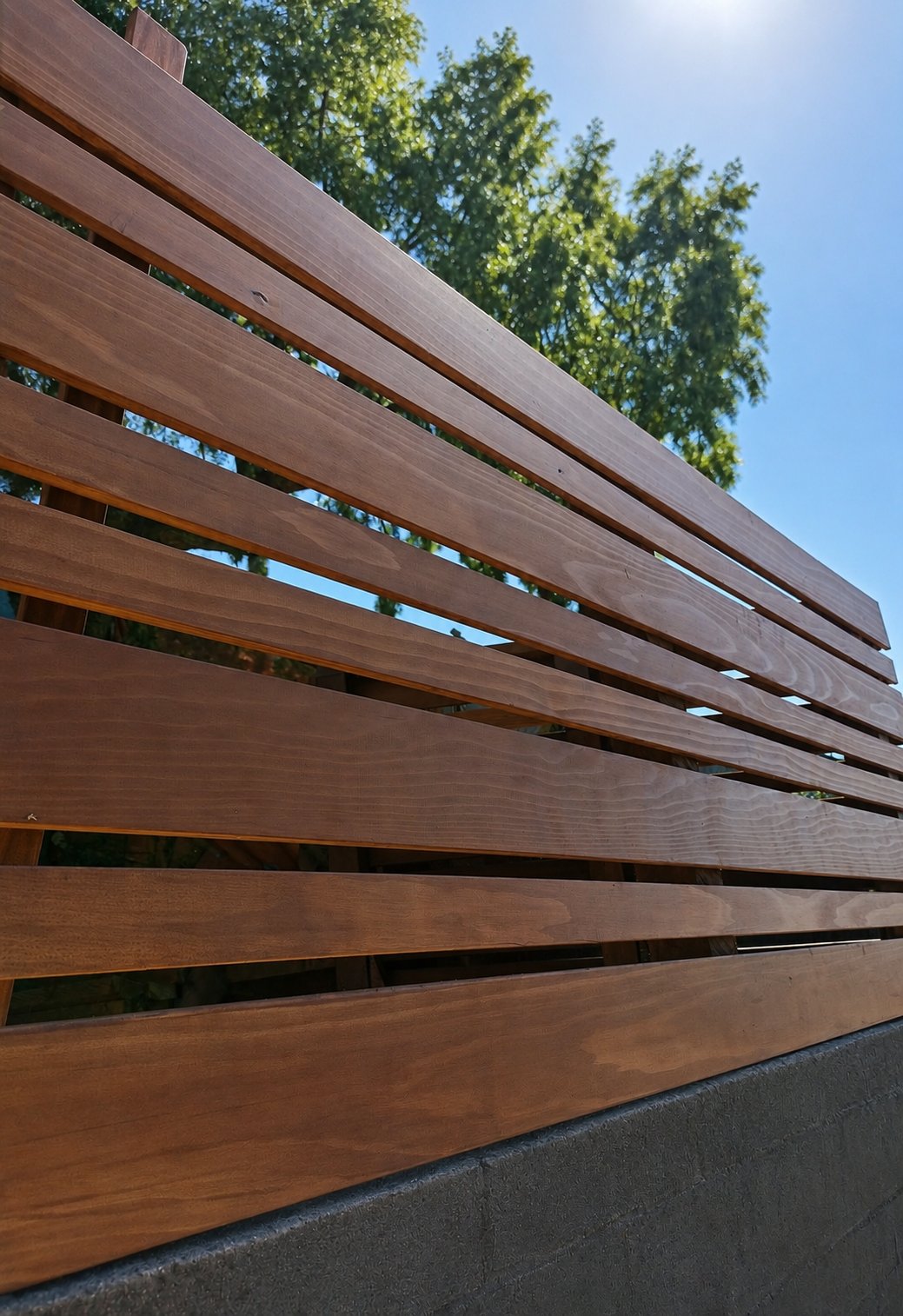 Close-up of warm honey stained horizontal cedar planks on hillside fence in Los Angeles