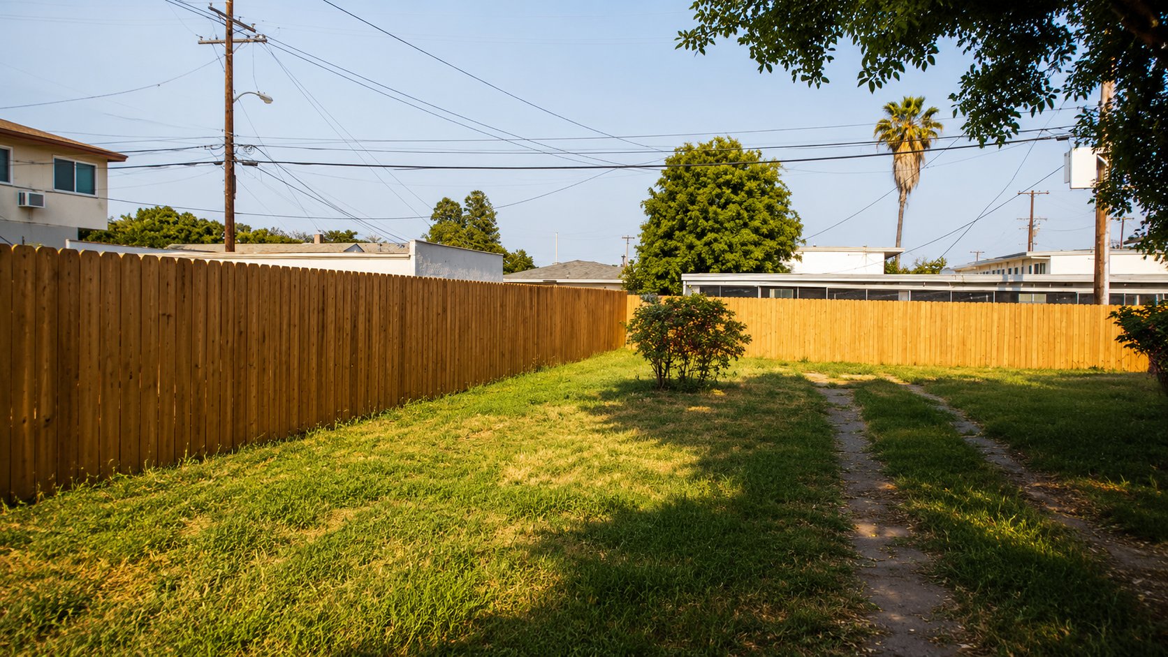 Two sections of dog-ear cedar privacy fence meeting at a yard corner in Burbank, California