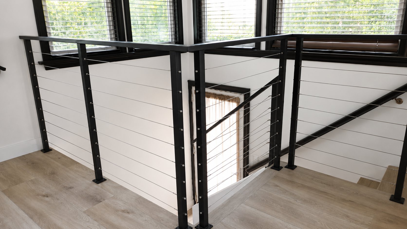 Corner of black steel and stainless cable railing on second-floor loft, LA interior