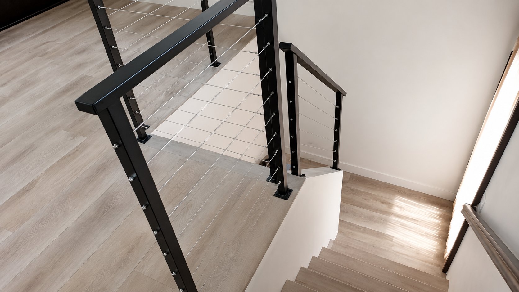 Black steel cable railing along staircase from top landing in Los Angeles home