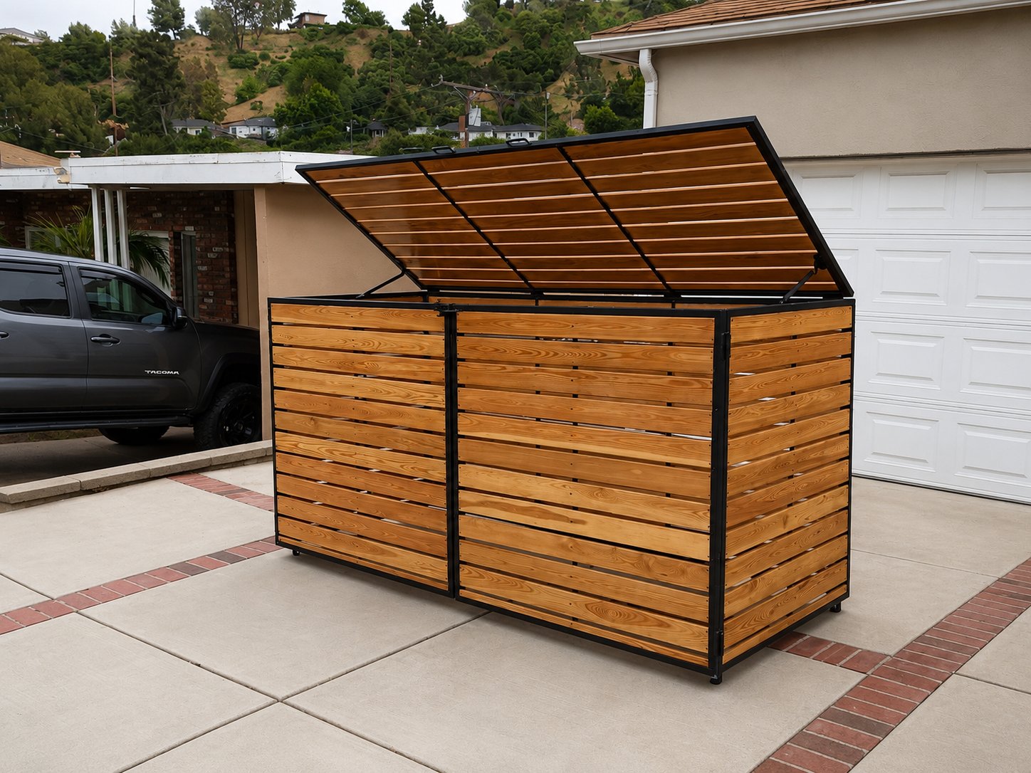 Steel-framed cedar trash enclosure with hinged lift-up lid open in LA driveway