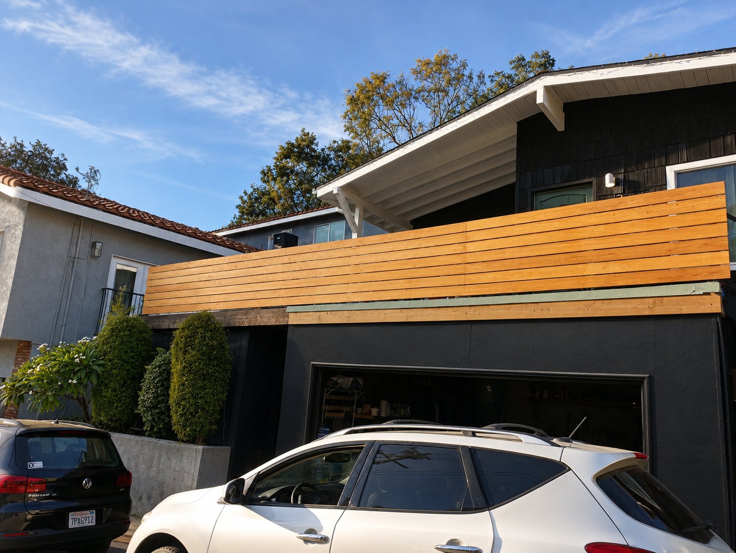 Cedar-and-steel balcony privacy screen viewed from the street — Los Angeles