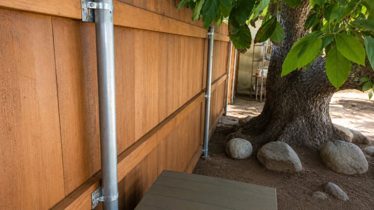 Galvanized steel post structure behind cedar wood fence, LA