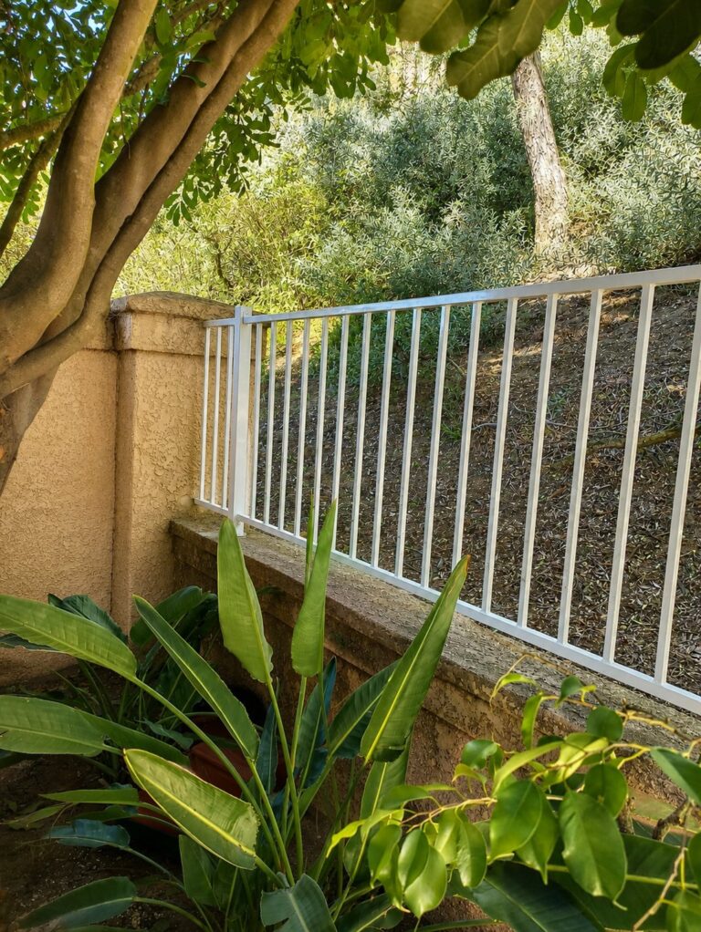 Steel railing following hillside slope above garden path — Los Angeles