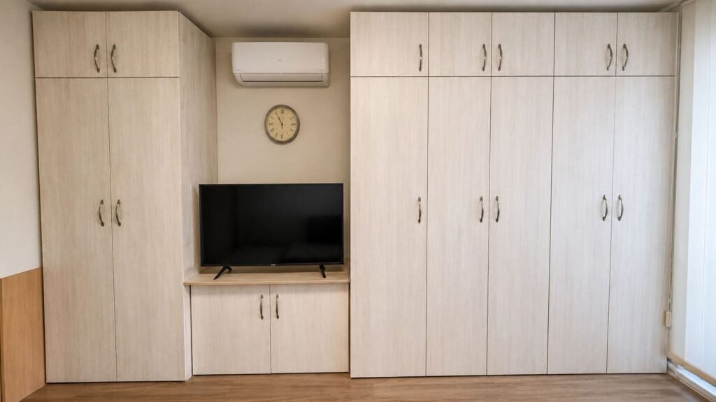Custom-built apartment media wall cabinets with TV shelf, wardrobes and HVAC surround — Los Angeles ProHands