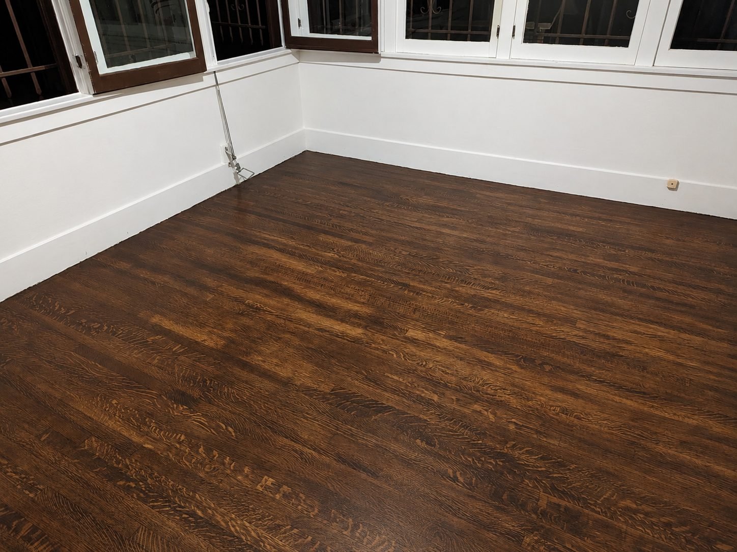 Oak parquet floor restoration in Los Angeles room with tall bay windows and satin finish — ProHands