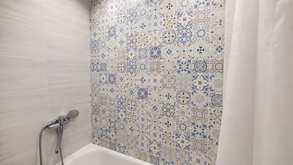 Patterned encaustic-look tile tub surround feature wall with marble-look side tile and chrome shower — Los Angeles ProHands