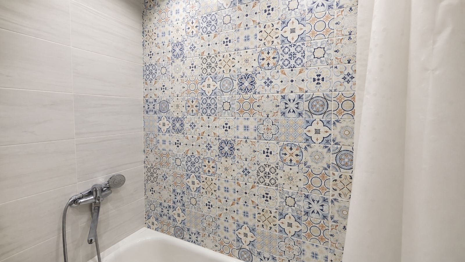 Patterned encaustic-look tile tub surround feature wall with marble-look side tile and chrome shower — Los Angeles ProHands