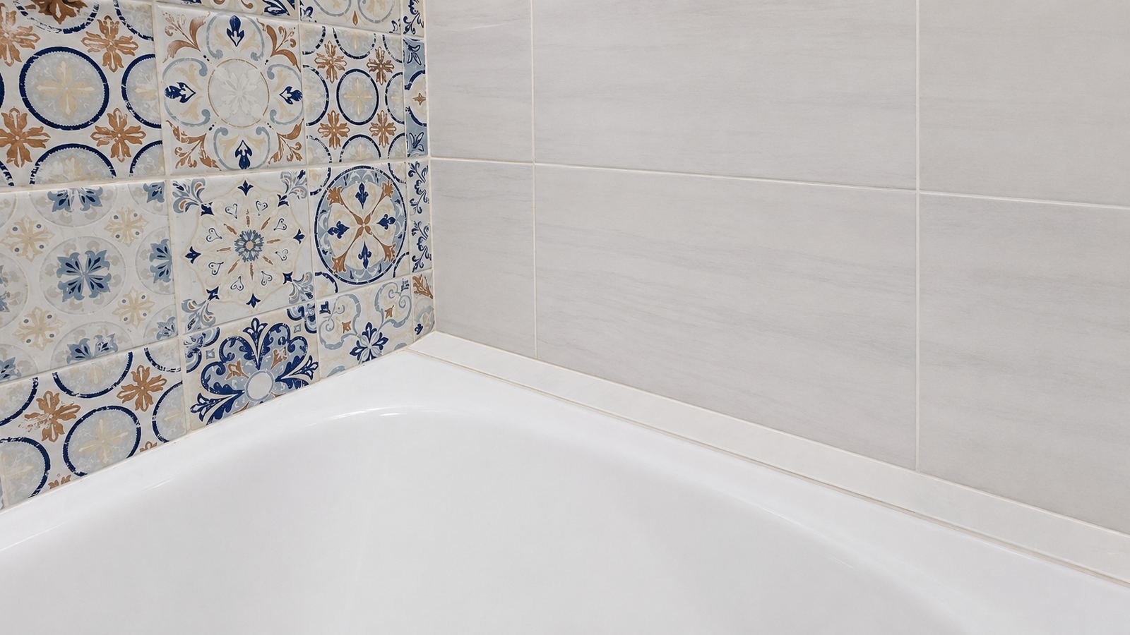 Corner detail where patterned tile meets marble-look tile above white tub — ProHands Los Angeles bathroom