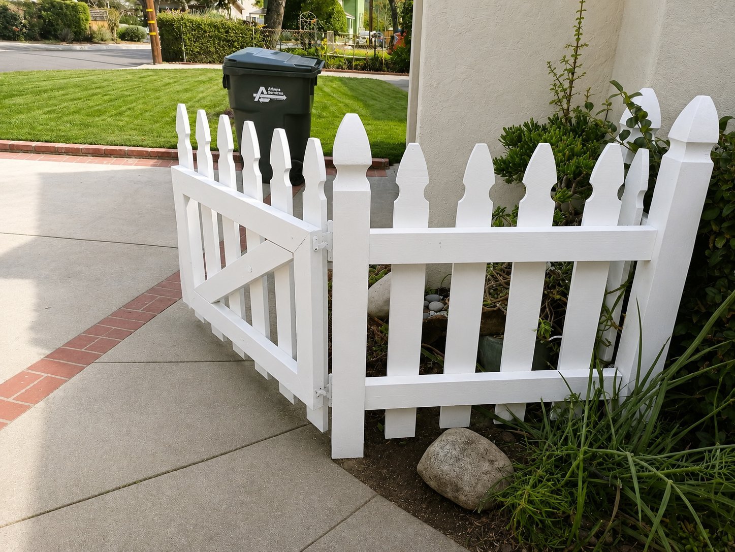 White picket fence anchored to red brick base in Glendale CA