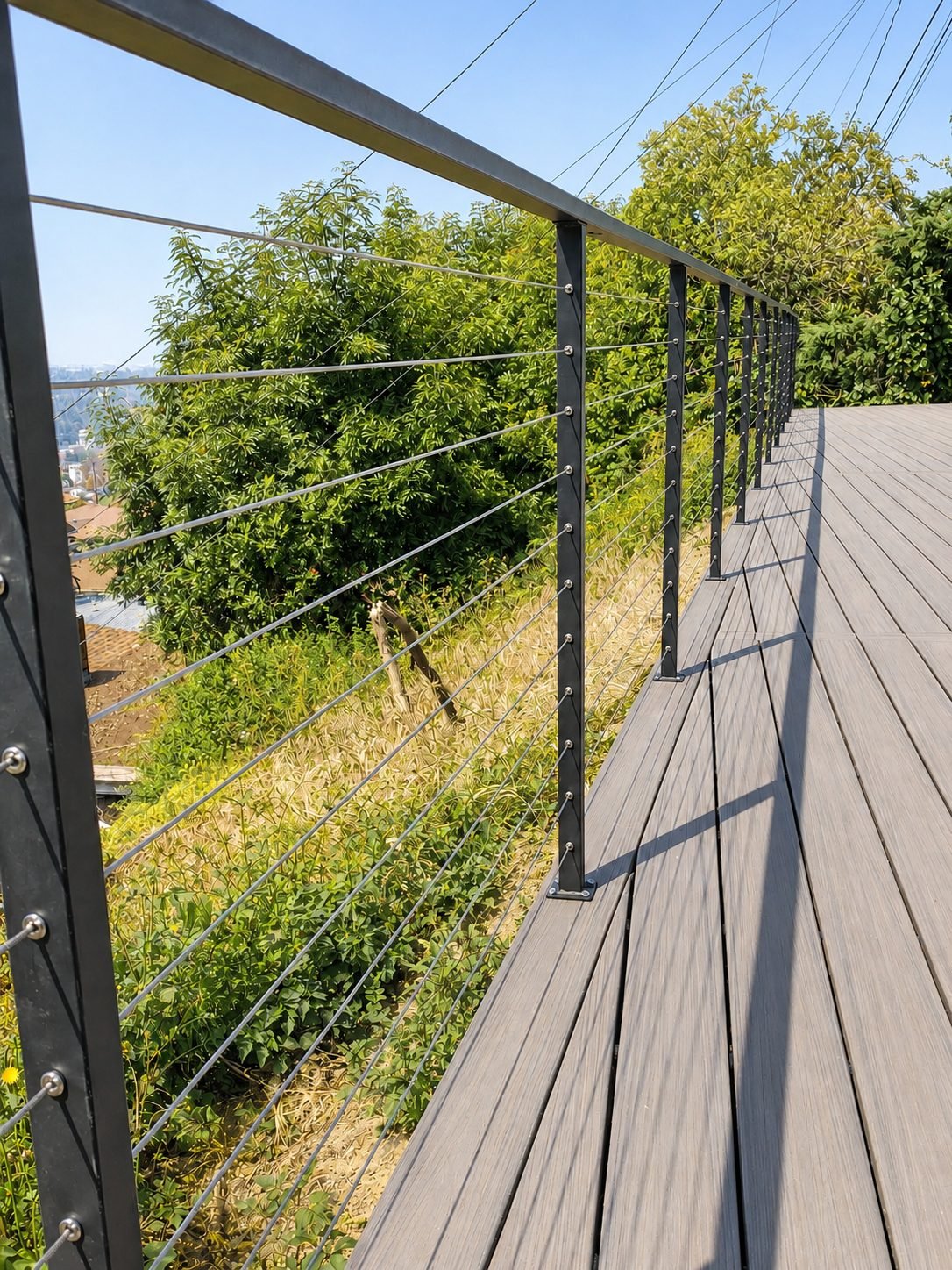 Composite deck with black steel and stainless cable railing on a hillside with view — ProHands Los Angeles