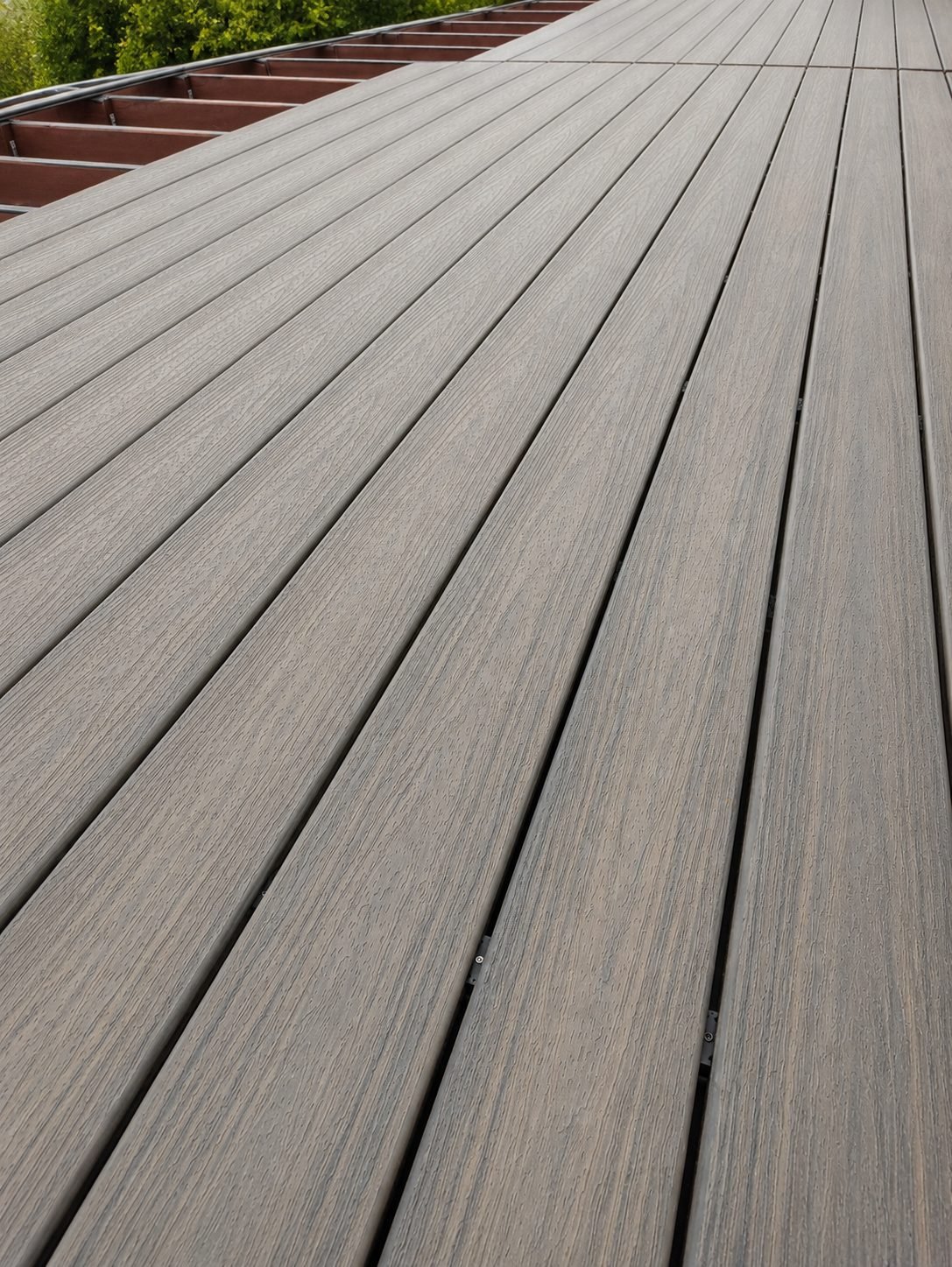 Composite deck alongside modern white house with multi-panel bifold glass doors — ProHands Los Angeles