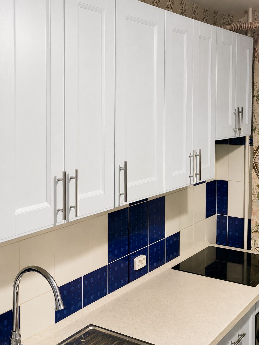 Full run of custom white shaker upper kitchen cabinets with brushed steel bar pulls above existing tile backsplash — ProHands Los Angeles