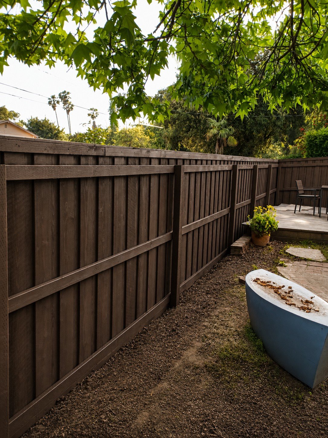 Espresso board-and-batten fence backyard side — framed panels with mid rail, kickboard at grade, dark chocolate stain — ProHands Los Angeles