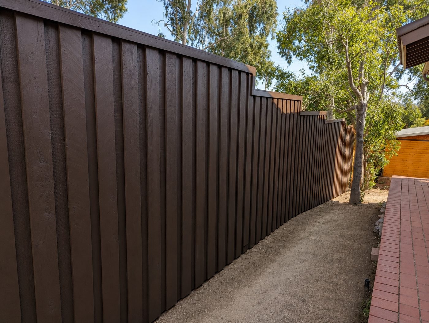 Board-and-batten cedar fence — full-height detail showing tight-fit cedar boards with vertical battens and chocolate brown stain finish — ProHands Los Angeles