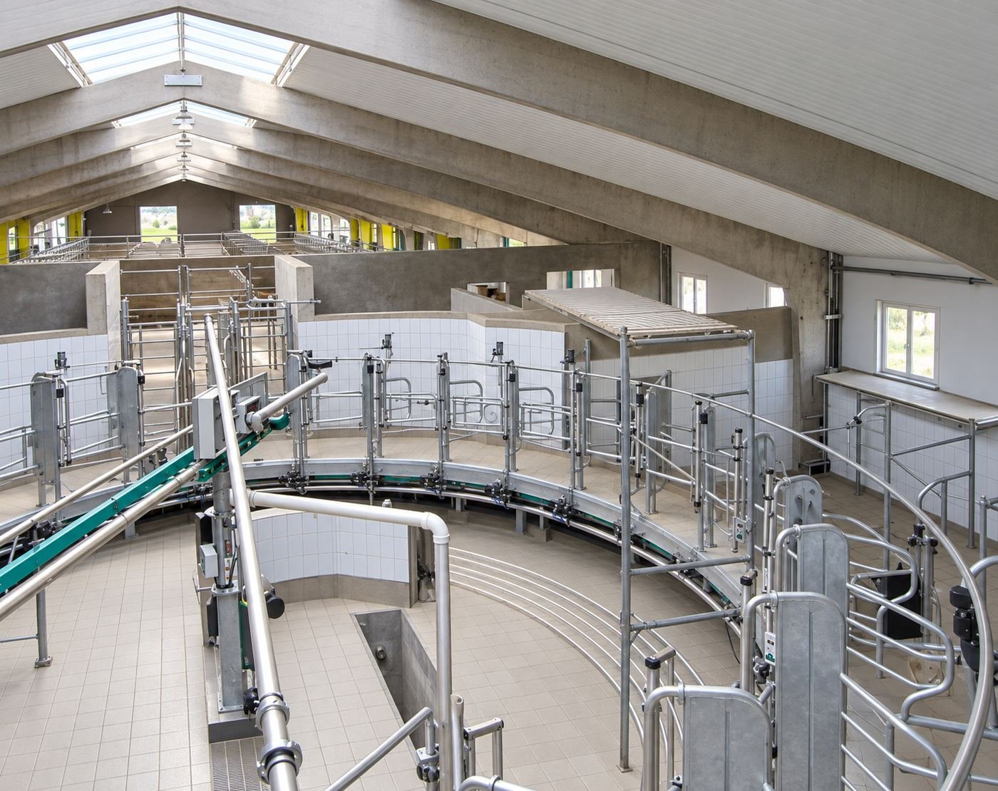 Finished rotary milking parlor we built in Russia — tiled walls, concrete arch ceiling with skylight, galvanized rotary carousel milking equipment and operator pit