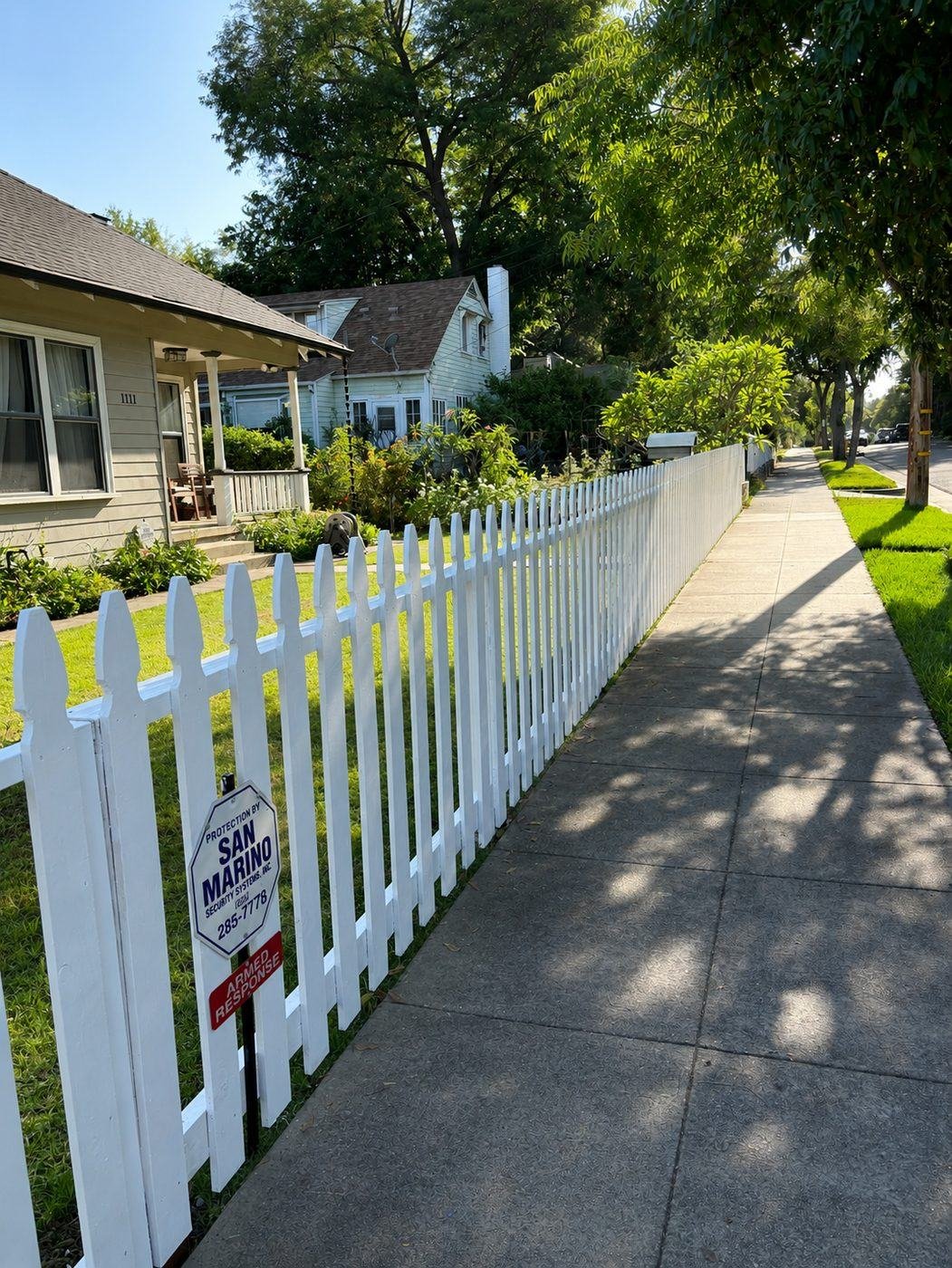 Sidewalk perspective of a classic white picket fence running along a Craftsman bungalow property in San Marino, Los Angeles — ProHands