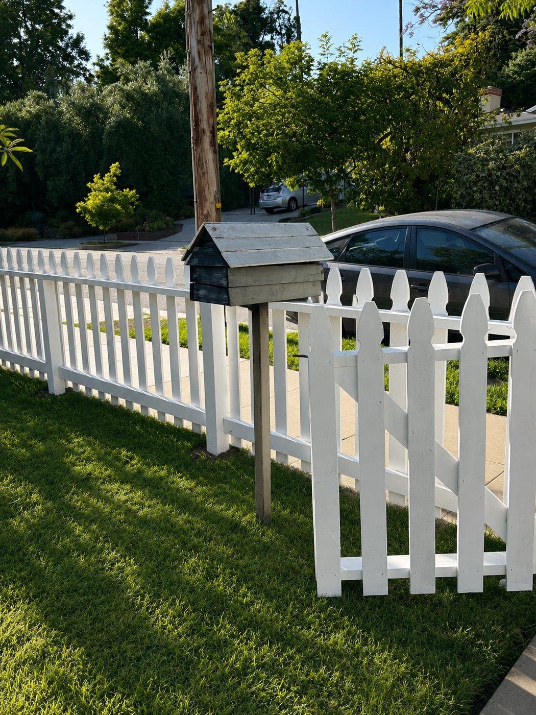Corner section of a classic white picket fence with walkway gate and wood mailbox at a Craftsman home in San Marino, Los Angeles — ProHands