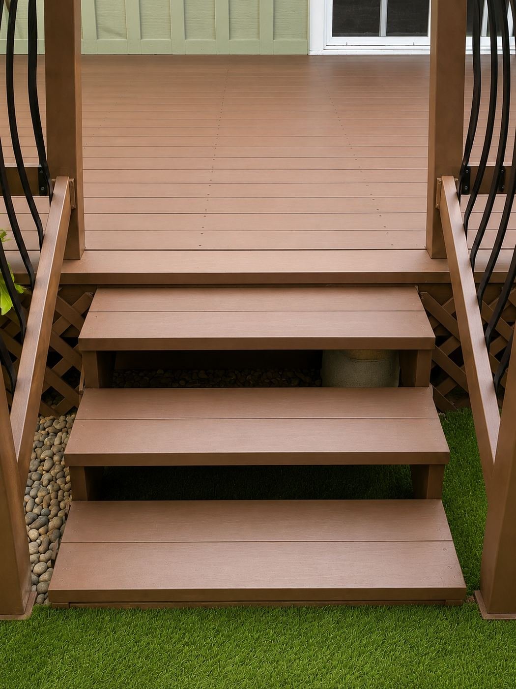 Three-tread wood deck stairs after full board replacement and repaint, river-rock drainage bed and lattice skirt on the sides — ProHands Los Angeles