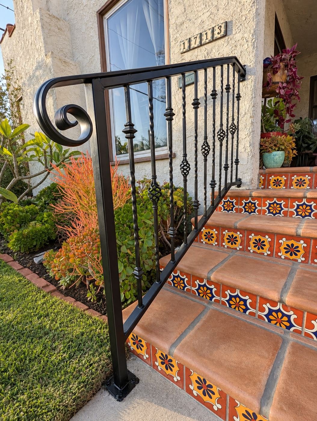Left-side custom wrought-iron handrail with twisted balusters, basket spirals and large hand-formed scroll end at golden hour — ProHands shop fabrication, LA