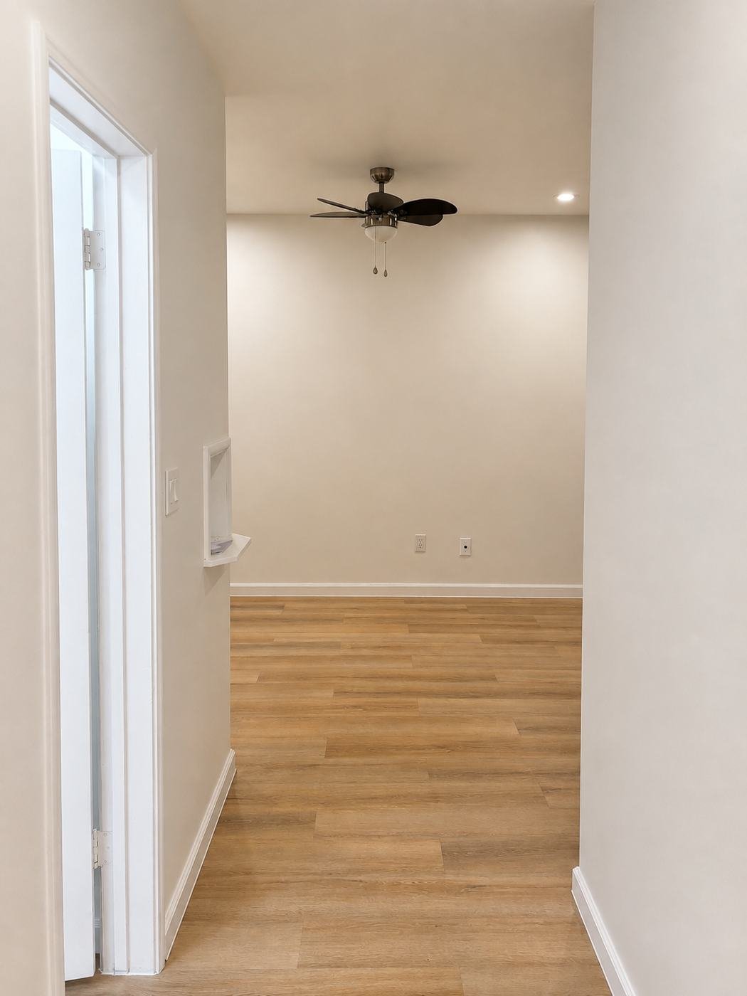 Bedroom entryway after remodel — bright white walls, built-in display niche, new LVP floor and clean baseboards — ProHands Los Angeles