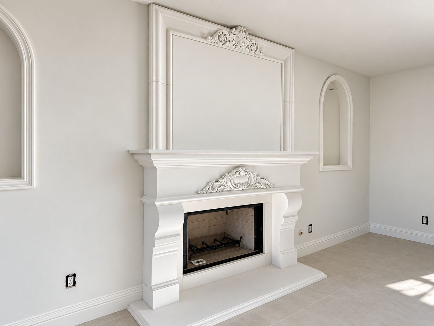 Side view of a formal room with limestone fireplace, arched niches and travertine floor — Mediterranean mansion remodel, Los Angeles