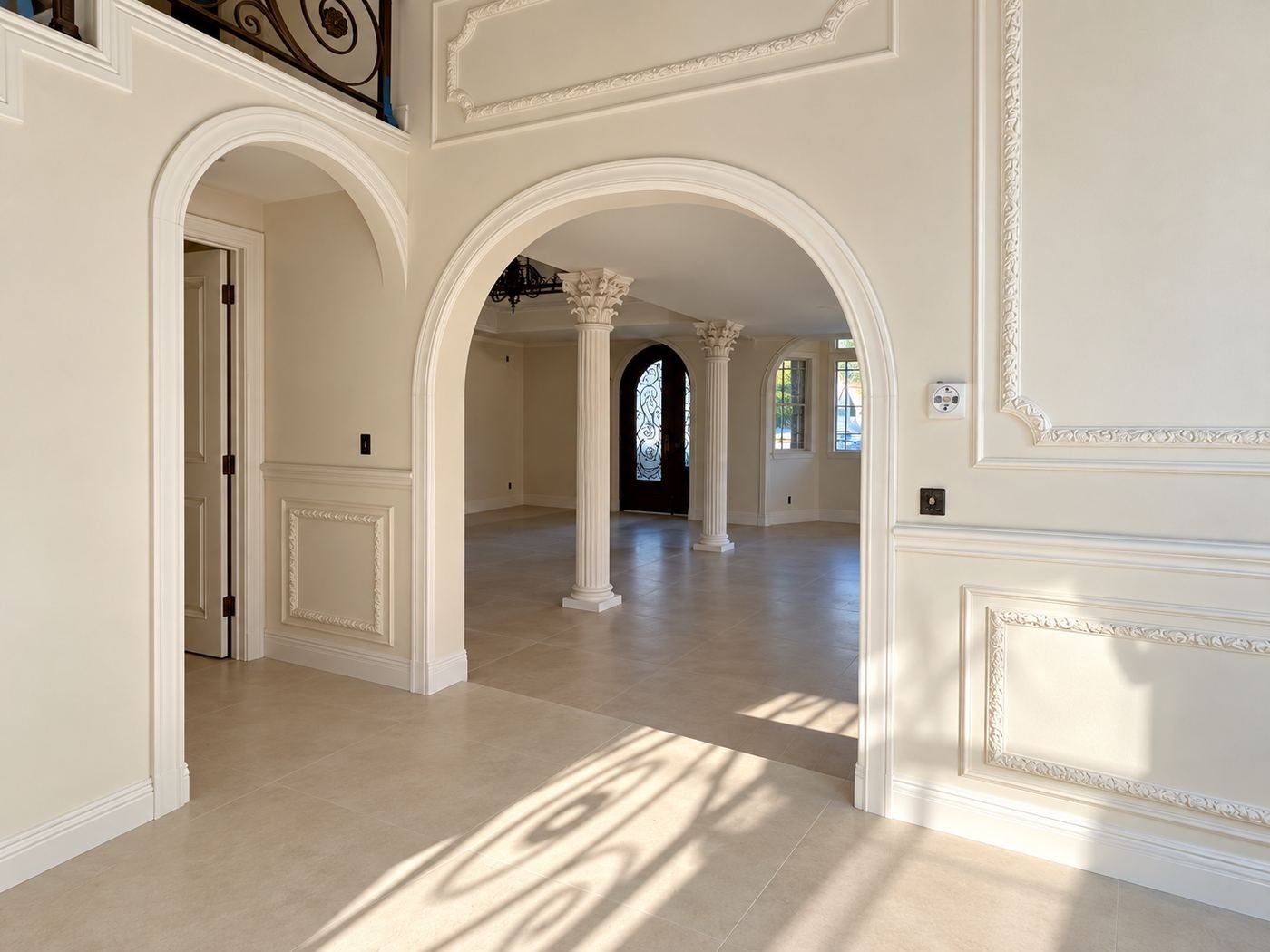 Arched hallway run through the formal zone of the mansion — multiple arches and columns, travertine floor — Mediterranean mansion remodel, Los Angeles
