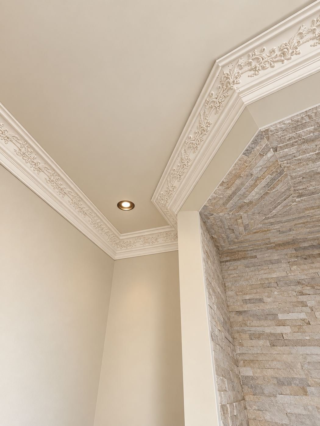 Side view of the master bath stone shower with the stacked-stone niche visible — crisp white crown molding at the ceiling, arched window in the next room — Mediterranean mansion remodel, Los Angeles
