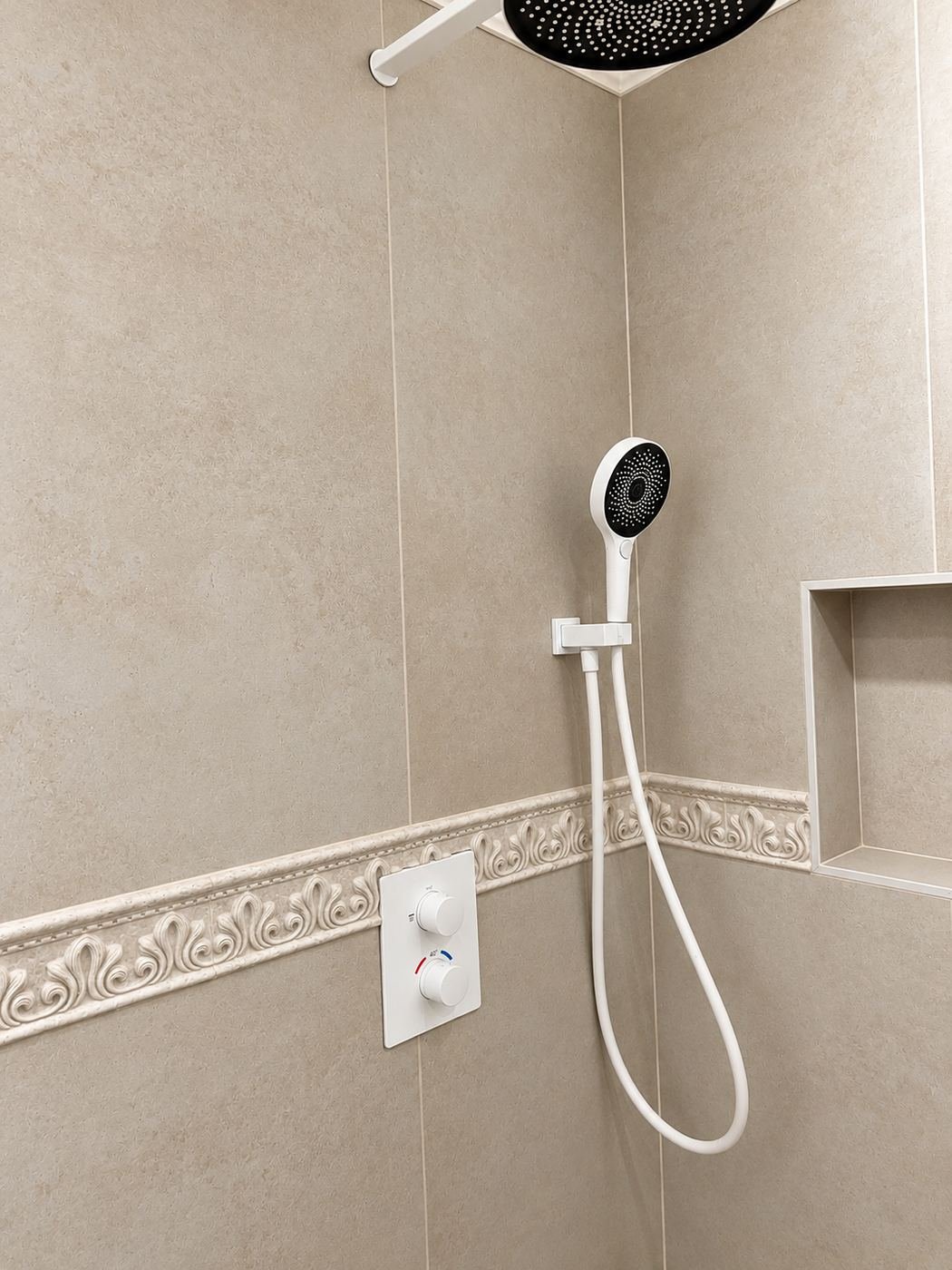 Secondary bath shower with a decorative plaster chair-rail cap running around the whole room, overhead rain head, mounted hand-shower on a wall niche with built-in soap shelf — Mediterranean mansion remodel, LA