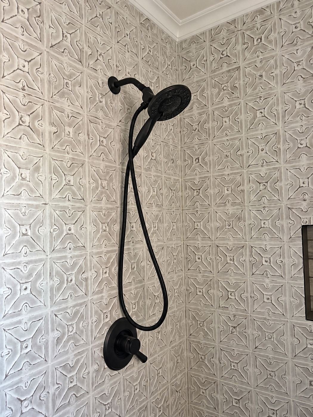 Tin-tile shower with matte-black rain head, matte-black hand-shower and matte-black control — different bath, same tin-tile language with a dark fixture package — Mediterranean mansion remodel, LA