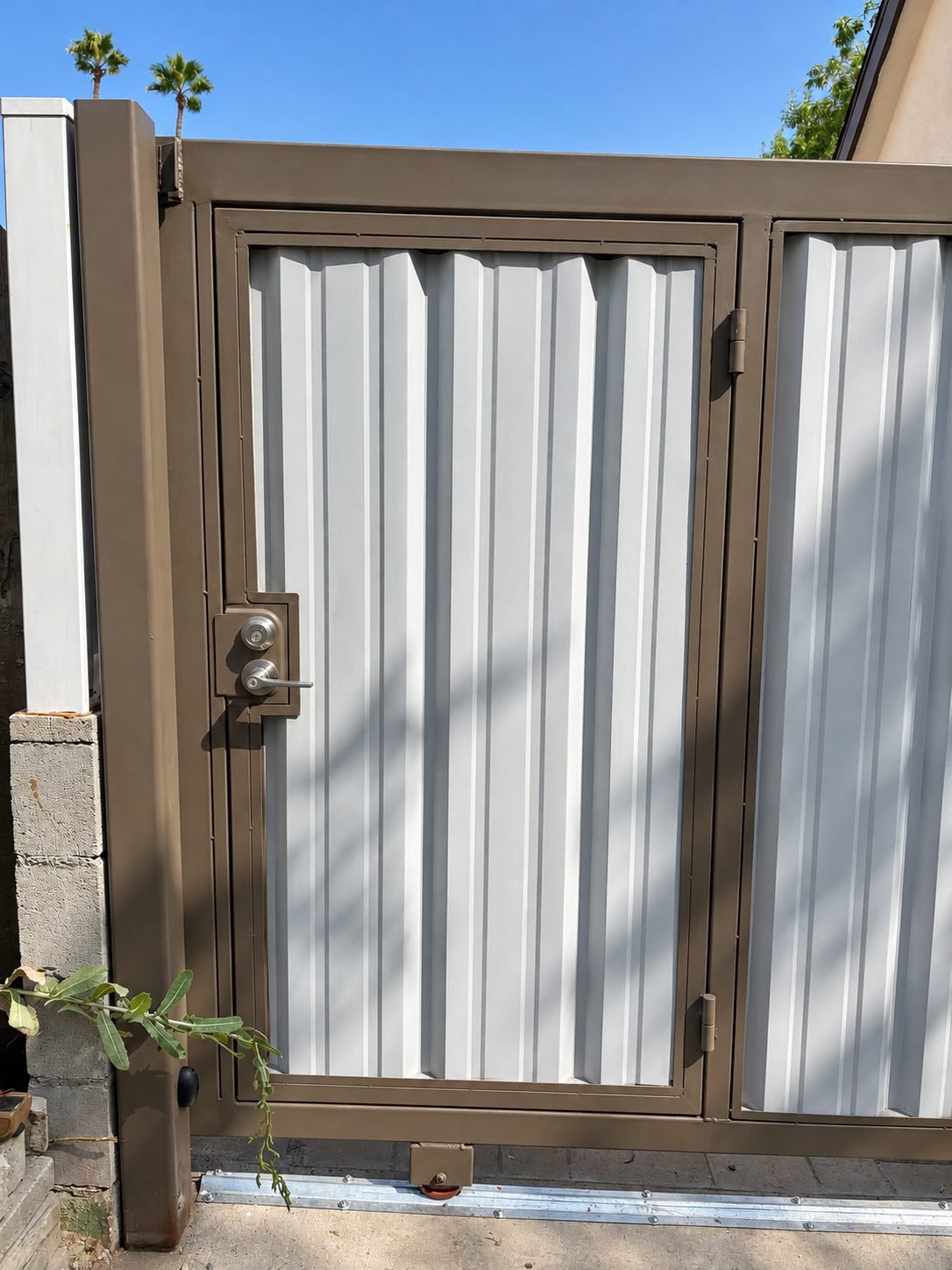 Pedestrian door at the back of utility access — grey steel panels in brown frame