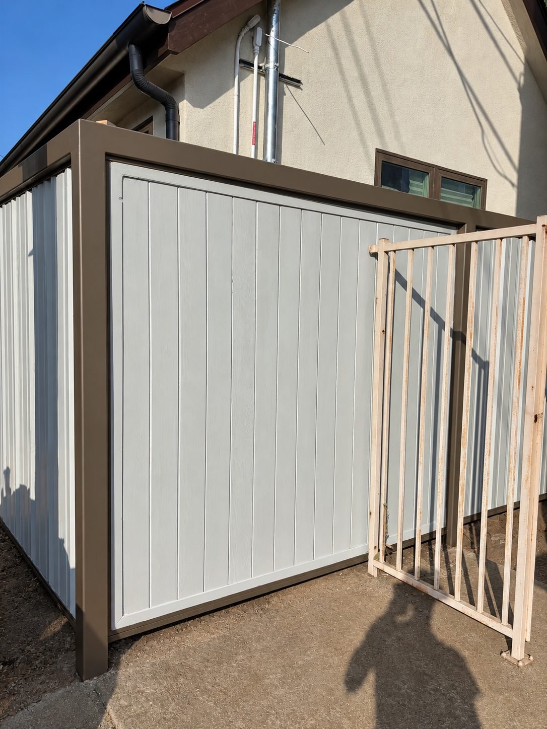 Utility enclosure in grey panels, framed and painted around electrical equipment
